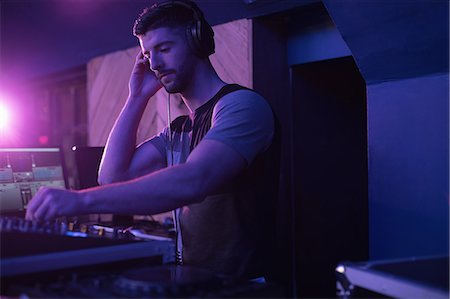 Male dj listening to headphones while playing music in bar Foto de stock - Sin royalties Premium, Código: 6109-08944503