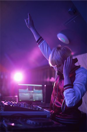 simsearch:700-00551346,k - Pretty female dj waving her hand while playing music in bar Foto de stock - Sin royalties Premium, Código: 6109-08944501