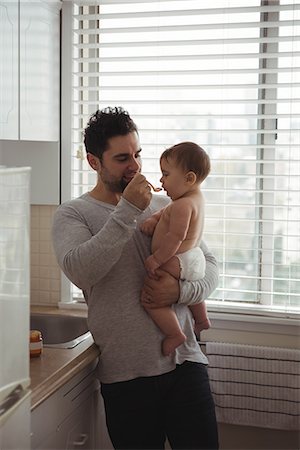 dar de comer - Father feeding his baby in kitchen at home Foto de stock - Sin royalties Premium, Código: 6109-08944675