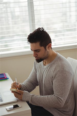 simsearch:6109-08537097,k - Handsome man writing on sticky note at home Stock Photo - Premium Royalty-Free, Code: 6109-08944687