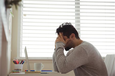 simsearch:6109-08944685,k - Stressed man sitting with hands on head at home Stock Photo - Premium Royalty-Free, Code: 6109-08944686