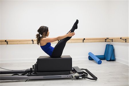 pilates reformer - Woman exercising on reformer in gym Foto de stock - Sin royalties Premium, Código: 6109-08944798