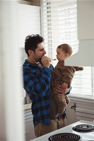 simsearch:6109-08537057,k - Father feeding his baby in kitchen at home Stock Photo - Premium Royalty-Free, Code: 6109-08944737