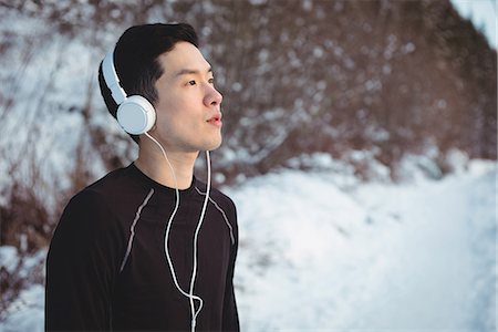 simsearch:649-08924632,k - Thoughtful man listening to music in headphones during winter Stock Photo - Premium Royalty-Free, Code: 6109-08944885