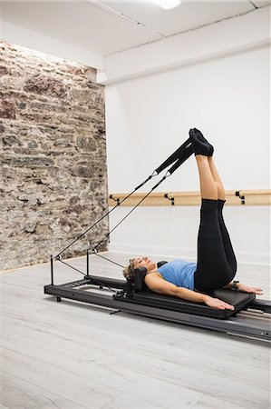 simsearch:6109-06004297,k - Woman exercising on reformer in gym Stockbilder - Premium RF Lizenzfrei, Bildnummer: 6109-08944807