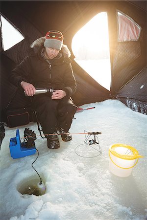 simsearch:400-04032721,k - Handsome Ice fisherman drinking coffee in his tent Stock Photo - Premium Royalty-Free, Code: 6109-08944826