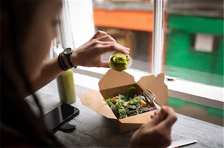 simsearch:649-09148681,k - Woman pouring green sauce on a salad in café Stockbilder - Premium RF Lizenzfrei, Bildnummer: 6109-08944942