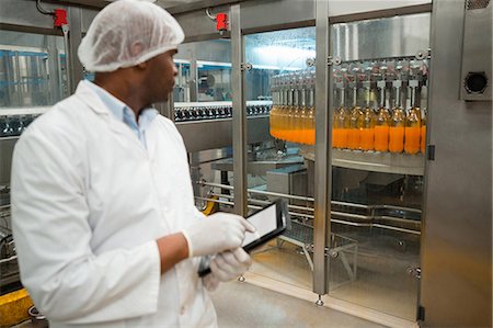 simsearch:6109-08945072,k - Male worker holding digital tablet while inspecting juice bottles in factory Stock Photo - Premium Royalty-Free, Code: 6109-08945061