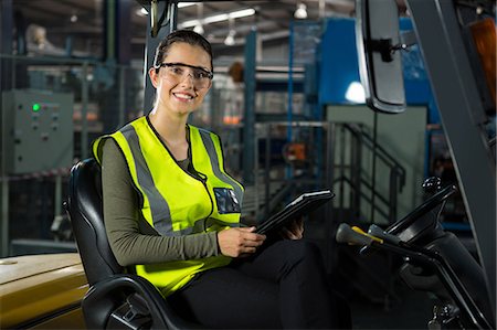 simsearch:6109-08945085,k - Portrait of beautiful female worker with digital tablet in forklift at warehouse Stock Photo - Premium Royalty-Free, Code: 6109-08945096