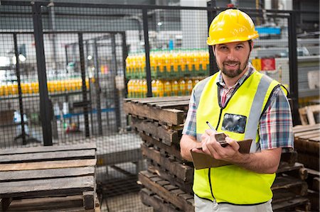 Portrait of smiling male worker noting about products in warehouse Stock Photo - Premium Royalty-Free, Code: 6109-08945110