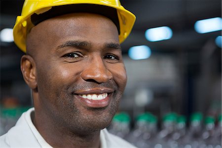 professional workers - Close up portrait of smiling male worker wearing hard hat in warehouse Stock Photo - Premium Royalty-Free, Code: 6109-08945116