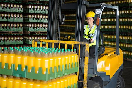 Confident female worker driving forklift in distribution warehouse Photographie de stock - Premium Libres de Droits, Code: 6109-08945119