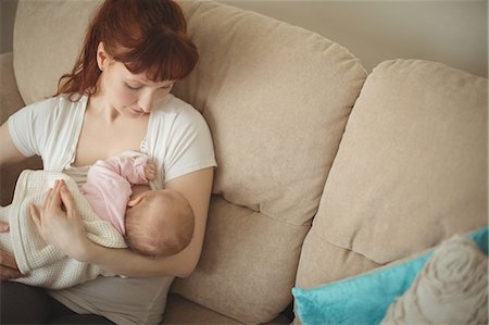 redhead baby girl - Loving mother breastfeeding baby on sofa in living room at home Foto de stock - Sin royalties Premium, Código: 6109-08945252