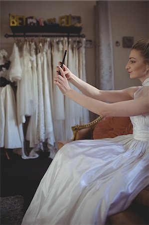 simsearch:670-06450341,k - Young bride taking a selfie in a boutique Photographie de stock - Premium Libres de Droits, Code: 6109-08945263