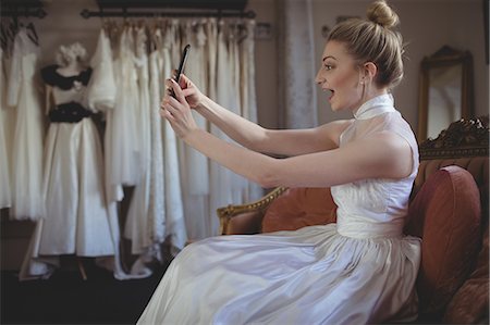 starting ceremony - Young bride taking a selfie in a boutique Foto de stock - Sin royalties Premium, Código: 6109-08945262