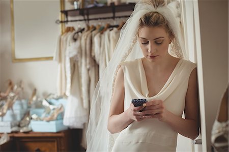simsearch:670-06450341,k - Young bride using mobile phone in a boutique Photographie de stock - Premium Libres de Droits, Code: 6109-08945270