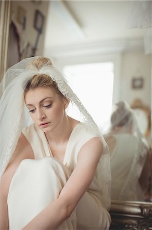 simsearch:6109-08945276,k - Thoughtful young bride in a white dress relaxing in boutique Photographie de stock - Premium Libres de Droits, Code: 6109-08945275