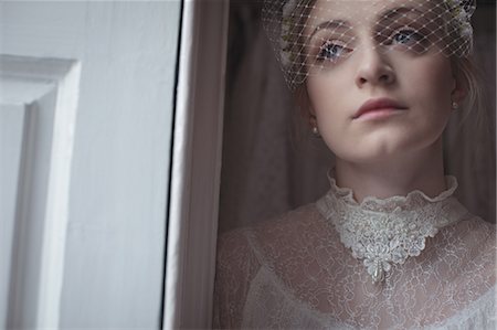 Close-up of young bridal wearing birdcage veil in a boutique Stock Photo - Premium Royalty-Free, Code: 6109-08945283