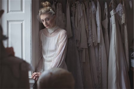 Portrait of young bride standing near window in a boutique Foto de stock - Sin royalties Premium, Código: 6109-08945282