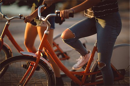 simsearch:6128-08738599,k - Low section of friend riding bicycle in morning Foto de stock - Royalty Free Premium, Número: 6109-08945454