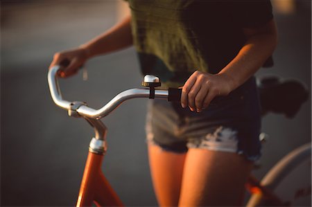 simsearch:6128-08738600,k - Low section of friend riding bicycle in morning Stock Photo - Premium Royalty-Free, Code: 6109-08945455