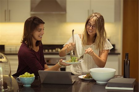 simsearch:6109-08944595,k - Happy friends using laptop while having breakfast in kitchen at home Photographie de stock - Premium Libres de Droits, Code: 6109-08945467