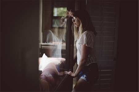simsearch:6109-08953348,k - Thoughtful woman looking through window at home Stock Photo - Premium Royalty-Free, Code: 6109-08945477