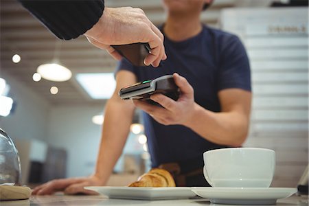 Customer making contactless payment with smartphone in coffee shop Photographie de stock - Premium Libres de Droits, Code: 6109-08945405