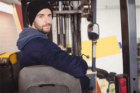 simsearch:6109-08952729,k - Portrait of mechanic sitting on forklift Fotografie stock - Premium Royalty-Free, Codice: 6109-08952643