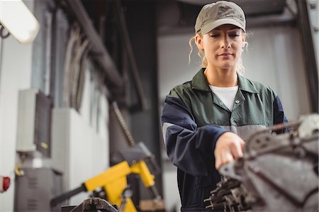 simsearch:6109-08952733,k - Female mechanic checking a car parts Stock Photo - Premium Royalty-Free, Code: 6109-08952662