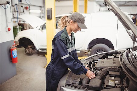 simsearch:6109-08782901,k - Female mechanic servicing car Stock Photo - Premium Royalty-Free, Code: 6109-08952667