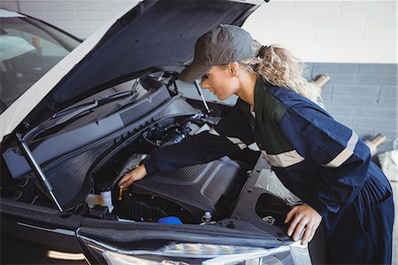 simsearch:6113-08321428,k - Female mechanic servicing car Photographie de stock - Premium Libres de Droits, Code: 6109-08952683