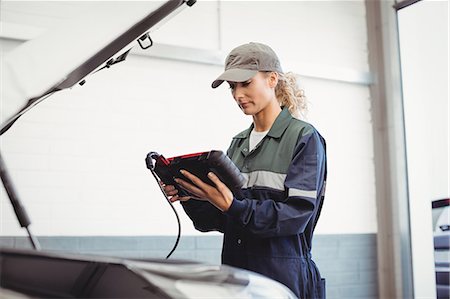 simsearch:6109-08952729,k - Female mechanic using electronic diagnostic device Stock Photo - Premium Royalty-Free, Code: 6109-08952687