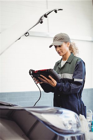 female mechanic - Female mechanic using electronic diagnostic device Foto de stock - Sin royalties Premium, Código: 6109-08952689