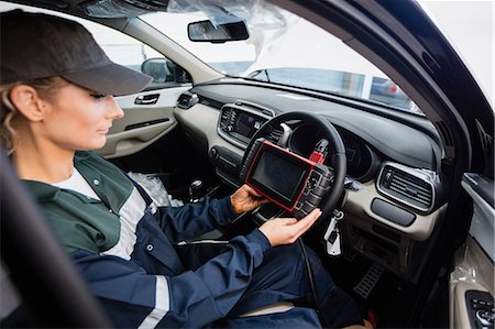 female mechanic - Female mechanic using electronic diagnostic device Foto de stock - Sin royalties Premium, Código: 6109-08952693