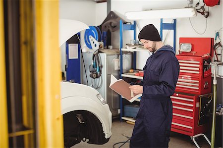 Mechanic reading instruction manual book Foto de stock - Royalty Free Premium, Número: 6109-08952635