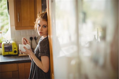 simsearch:6109-08944356,k - Portrait of woman having coffee in kitchen at home Stock Photo - Premium Royalty-Free, Code: 6109-08952782