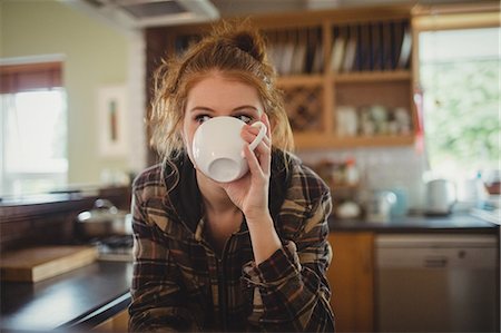 simsearch:6109-08953331,k - Woman having coffee in kitchen at home Stock Photo - Premium Royalty-Free, Code: 6109-08952788