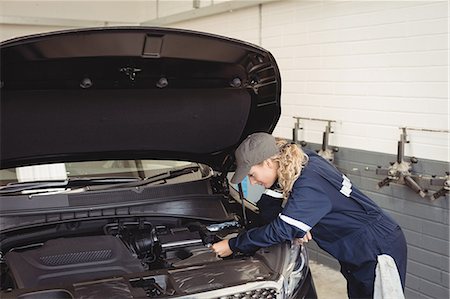 simsearch:6109-08952729,k - Female mechanic servicing car Fotografie stock - Premium Royalty-Free, Codice: 6109-08952701