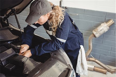 female mechanic - Female mechanic servicing car Foto de stock - Sin royalties Premium, Código: 6109-08952702