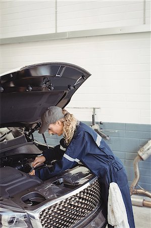 simsearch:614-08126572,k - Female mechanic servicing car Photographie de stock - Premium Libres de Droits, Code: 6109-08952704