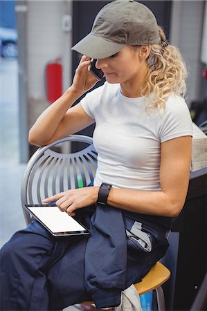 simsearch:6109-08782991,k - Female mechanic using digital tablet while talking on mobile phone Stock Photo - Premium Royalty-Free, Code: 6109-08952710