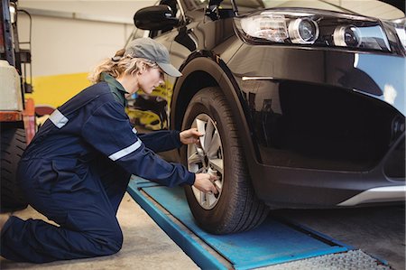 Female mechanic examining a car wheel Photographie de stock - Premium Libres de Droits, Code: 6109-08952717