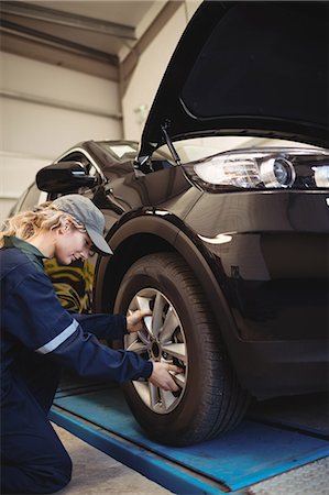 simsearch:6113-07565137,k - Female mechanic examining a car wheel Stock Photo - Premium Royalty-Free, Code: 6109-08952718