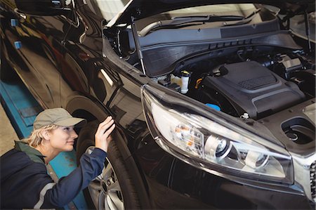 simsearch:6113-07565053,k - Female mechanic examining a car wheel Foto de stock - Sin royalties Premium, Código: 6109-08952719