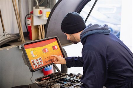 Mechanic using electronic diagnostic device Foto de stock - Sin royalties Premium, Código: 6109-08952727