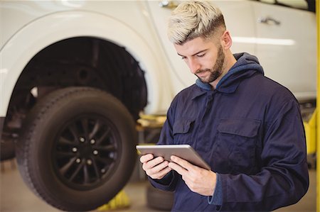 Mechanic using digital tablet Stock Photo - Premium Royalty-Free, Code: 6109-08952724