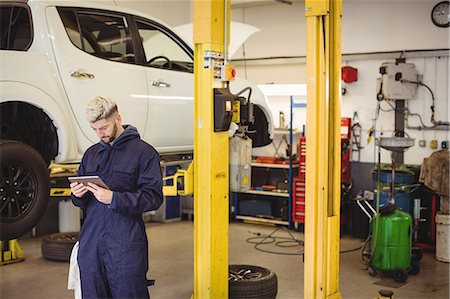 Mechanic using digital tablet Stock Photo - Premium Royalty-Free, Code: 6109-08952725