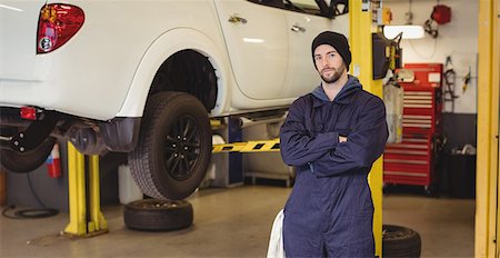 simsearch:6109-08537545,k - Mechanic standing with arms crossed in repair garage Foto de stock - Sin royalties Premium, Código: 6109-08952726