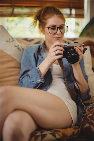 Woman looking at pictures on digital camera at home Photographie de stock - Premium Libres de Droits, Code: 6109-08952802
